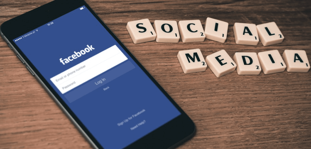 Facebook op een mobiele telefoon, met daarnaast de letters 'SOCIAL MEDIA'