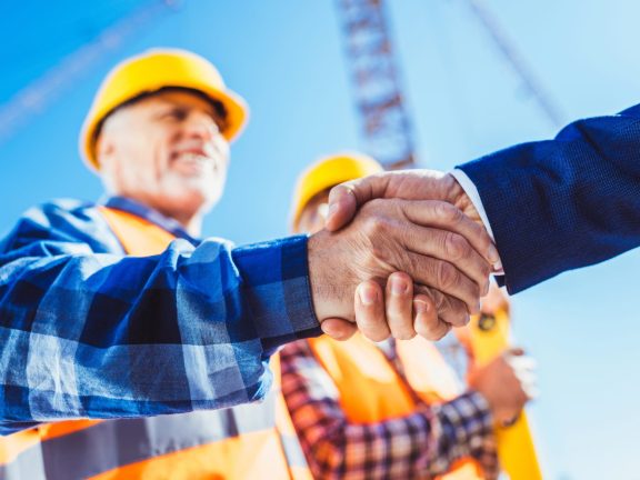 Builder and businessman shaking hands