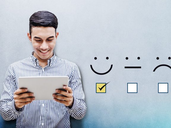 Customer Experience Concept, Happy Businessman holding digital Tablet with a checked box on Excellent Smiley Face Rating for a Satisfaction Survey