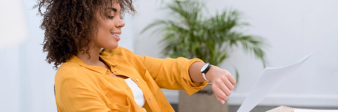 young african american woman at office looking at watch