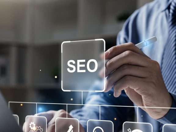 Hand of businessman holding a pen pointing to SEO Search Engine Optimization on laptop screen. Digital marketing process, Strategy,  Business Technology concept.