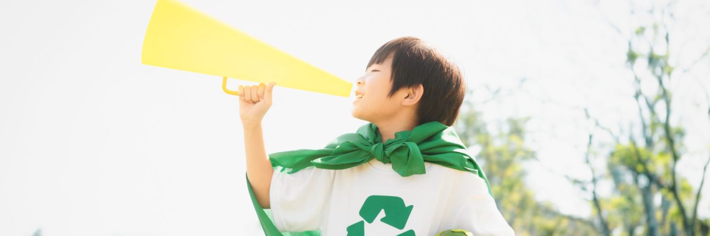 Young superhero boy with recycle symbol and cape make announcement with speaker on environmental awareness for eco-friendly waste recycling management as his mission to save Earth. Gyre