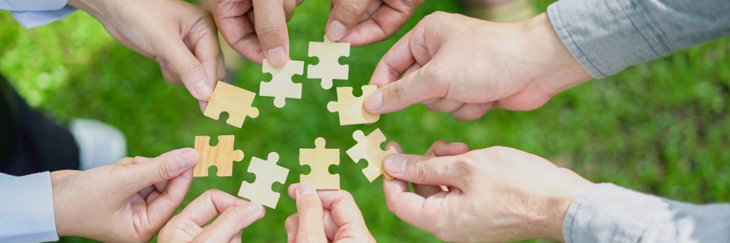 partnership, fitting together the pieces of environmental, social, and governance (ESG) strategies for sustainable success, symbolized by a jigsaw puzzle in hand.