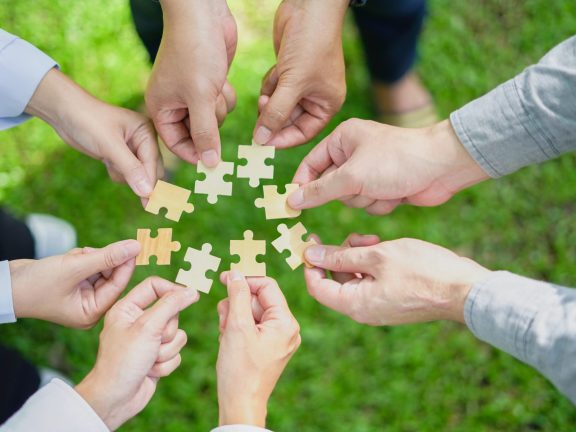 partnership, fitting together the pieces of environmental, social, and governance (ESG) strategies for sustainable success, symbolized by a jigsaw puzzle in hand.