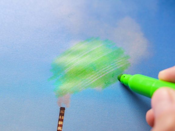 Man painting green pollution from a chimney