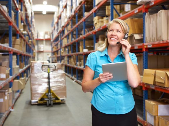 Businesswoman Using Digital Tablet In Distribution Warehouse