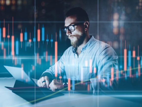 Double exposure.Market traider making analysis of digital market and investment in block chain crypto currency. Red and green candlestick chart and stock trading computer screen background.