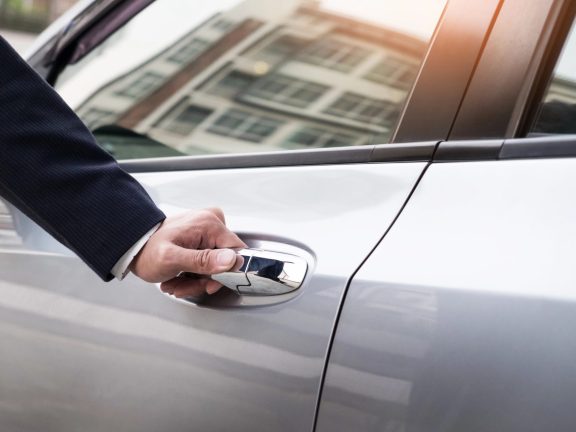 man in formal wear opening car door