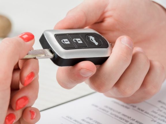 panoramic shot of realtor giving key to woman, leasing concept