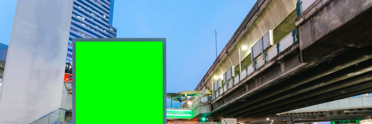 Blank billboard with green screen traffic city road long exposure background, copy space for your text on a street.