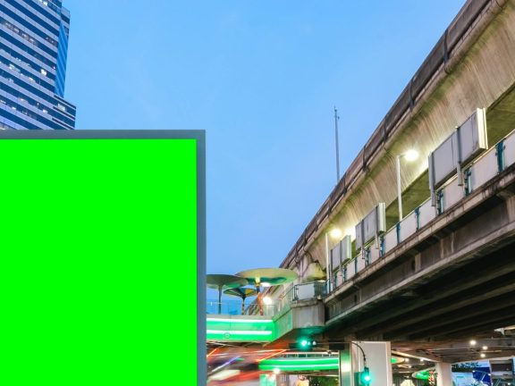 Blank billboard with green screen traffic city road long exposure background, copy space for your text on a street.
