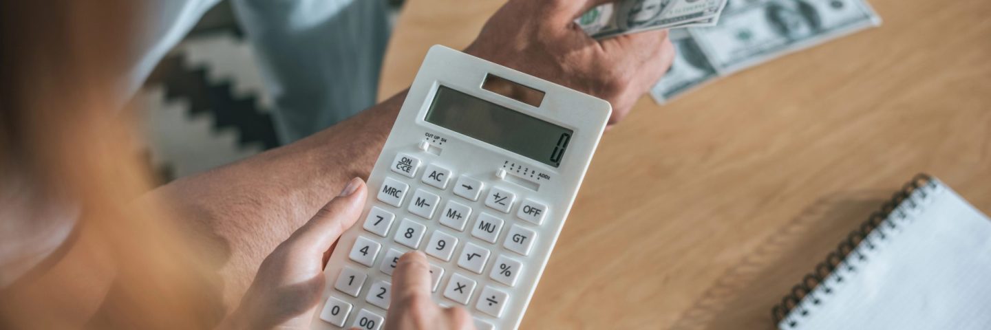 cropped image of couple planning family budget and calculating money in living room