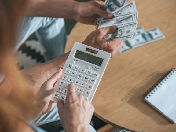 cropped image of couple planning family budget and calculating money in living room