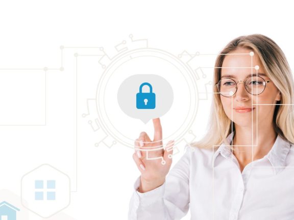 portrait of smiling businesswoman in formal wear pointing at cyber security sign isolated on white