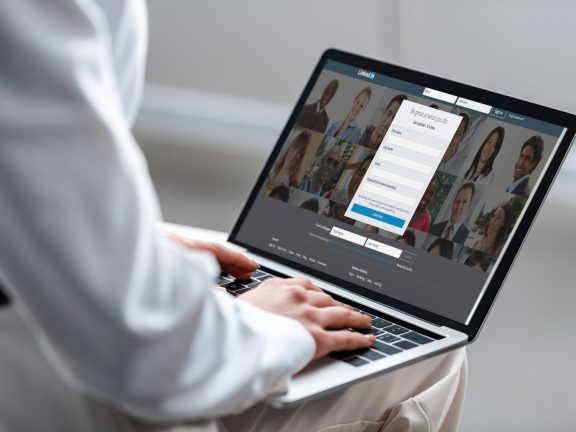 cropped view of woman using laptop with linkedin website on screen