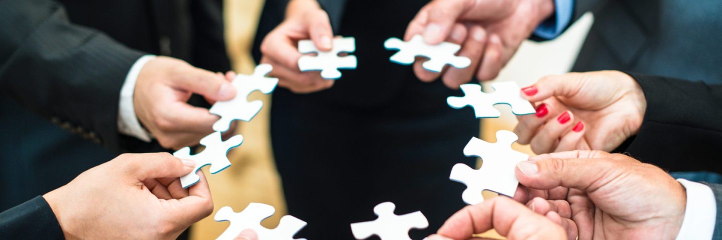 Teamwork - Business people solving a puzzle