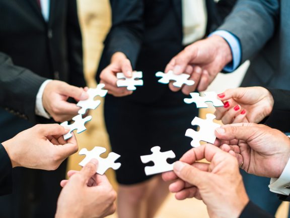 Teamwork - Business people solving a puzzle