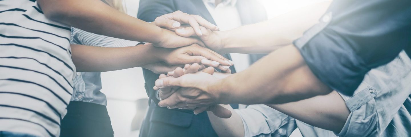 Close up view of young business people putting their hands together. Stack of hands. Unity and teamwork concept.