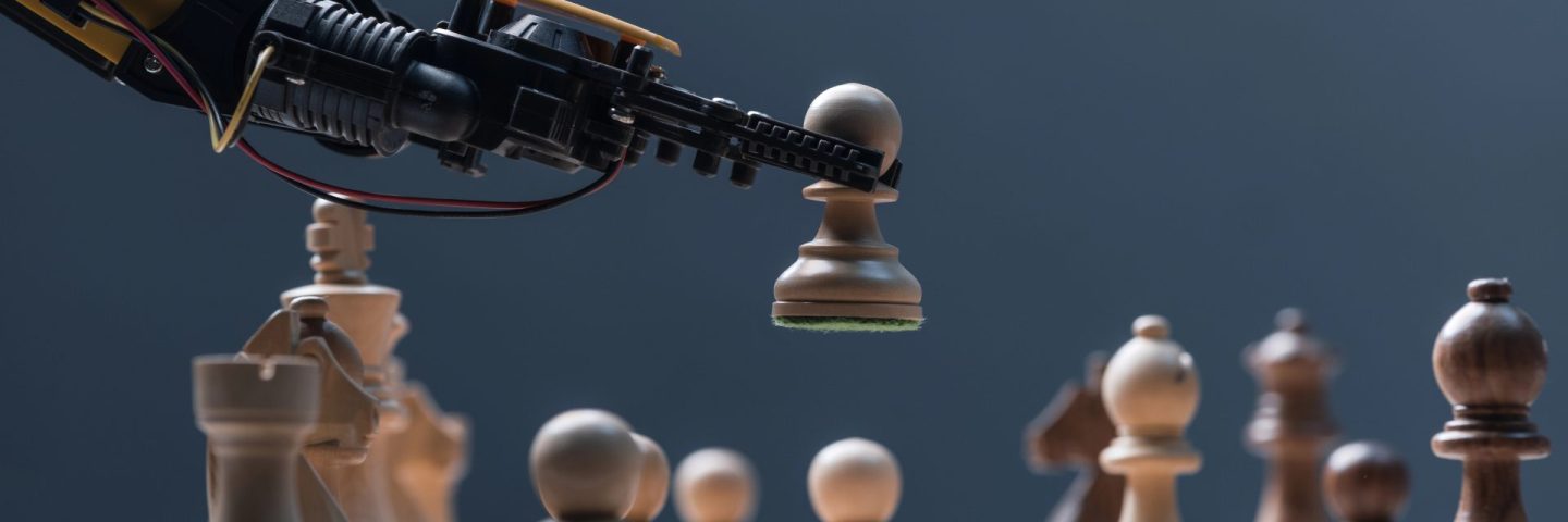 Robot moving chess pieces on chessboard, close up