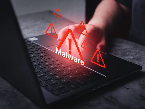 System hacked warning alert on laptop. Virus, Spyware, Malware or Malicious software. Woman receives warning notification on laptop.