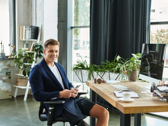 A young businessman with an artificial limb confidently works in a stylish office, embracing diversity.