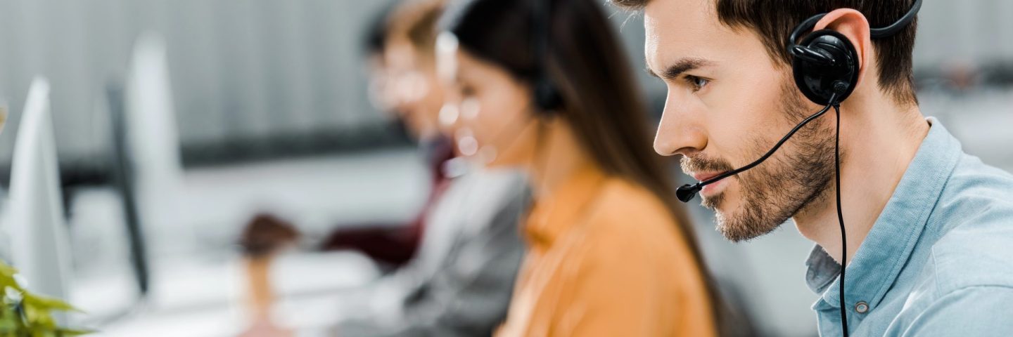 selective focus of call center operator in headset working in office