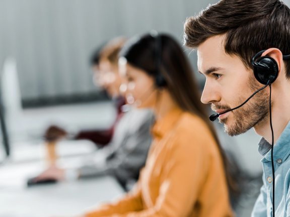 selective focus of call center operator in headset working in office
