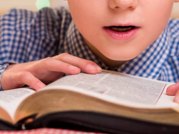 Kid reading book out loud.