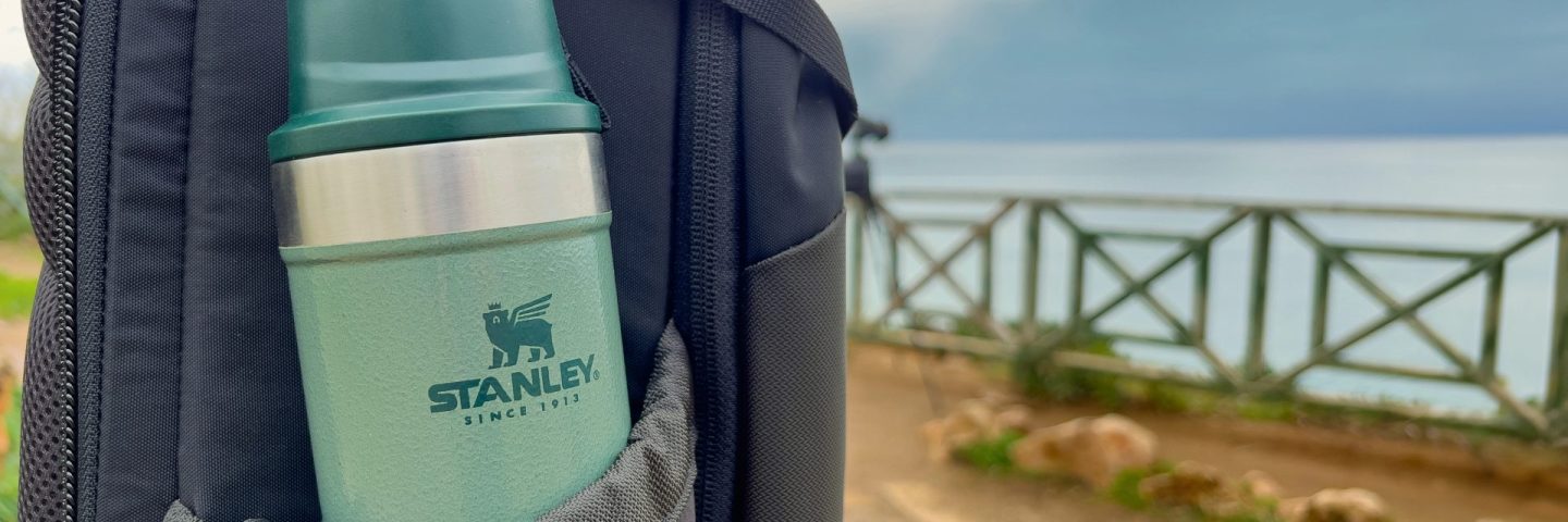 Antalya, Turkey - February 9, 2024: Stanley Action Trigger stands next to traveler's backpack