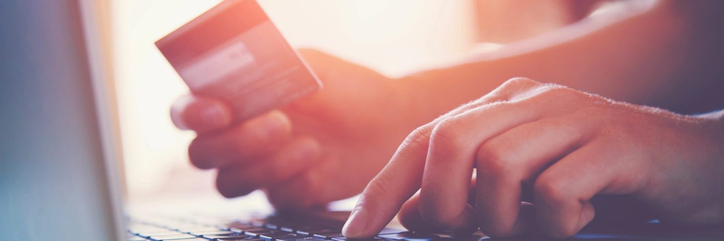 Hands holding credit card and using laptop. Online shopping