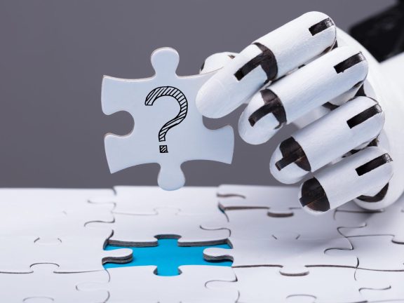 Close-up Of A Robotic Hand Solving Jigsaw Puzzle