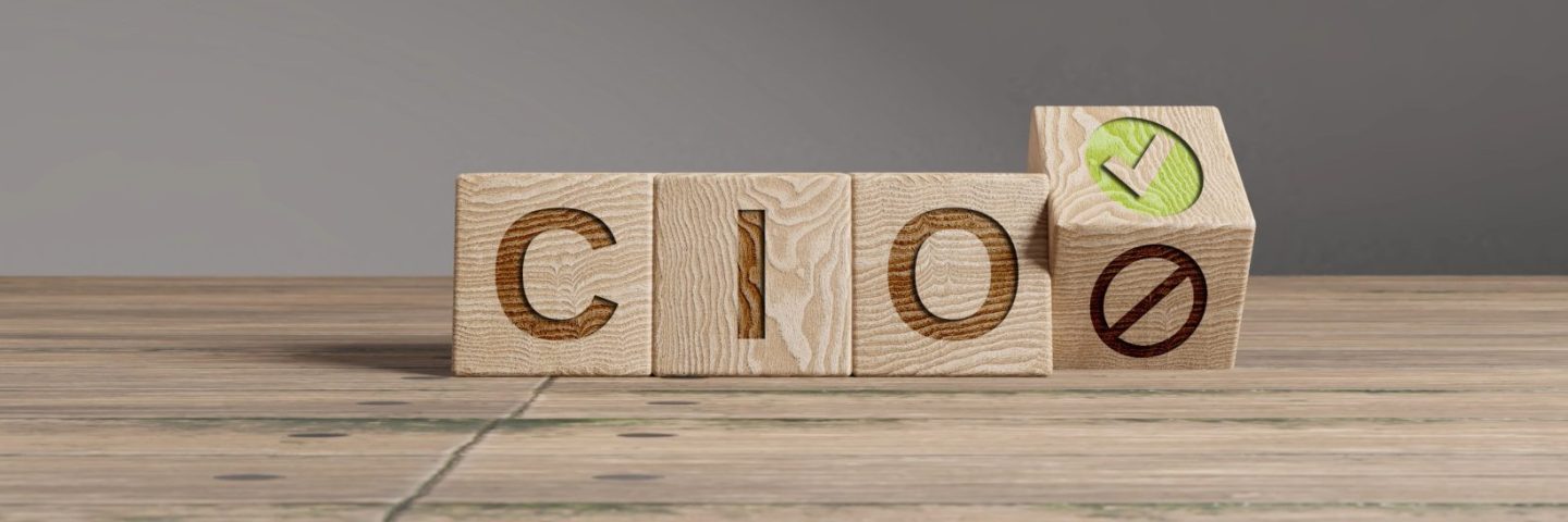 Wood cubes with acronym 'CIO' - 'Chief Information Officer' on a beautiful wooden table, studio background. Business concept with copy space.