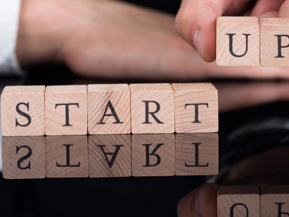 Businessman Arranging Startup Blocks On Desk