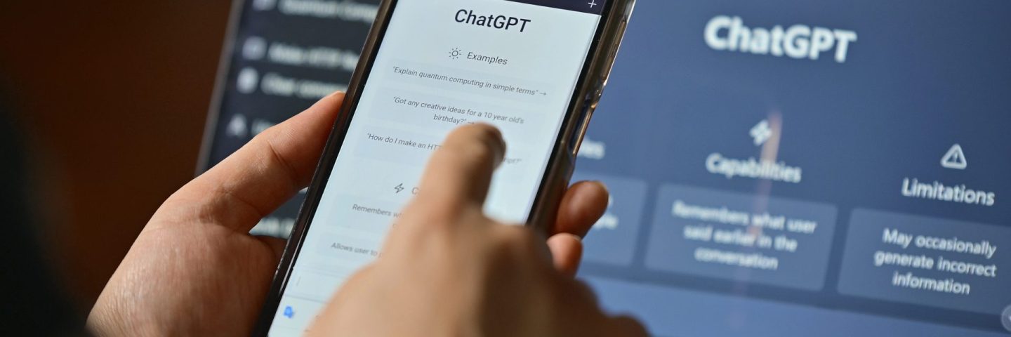 Seoul, South Korea - February, 2023 : Computer screen with ChatGPT website and person using mobile phone to ask questions to ChatGPT