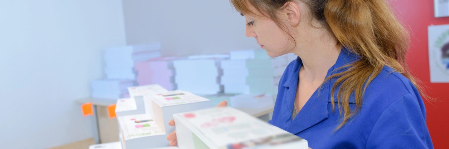 Woman with stacks of printed material