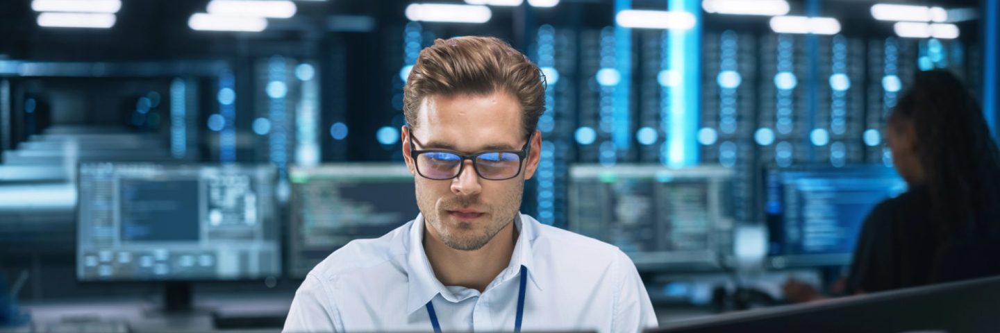 Focused System Administrator or Consultant Look at the Screen and Saves Backup Data in Dark Evening Room Workplace Station Indoors. Network Technologies Concept