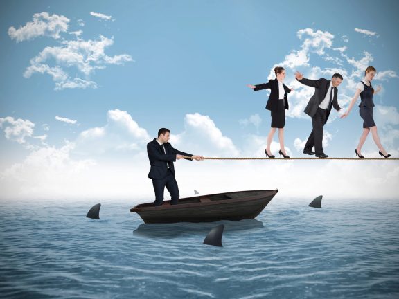 Young businessman pulling a tightrope for business people