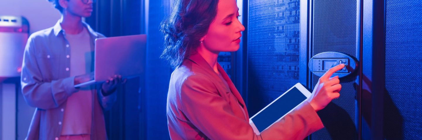 young engineer with digital tablet checking server near african american colleague with laptop