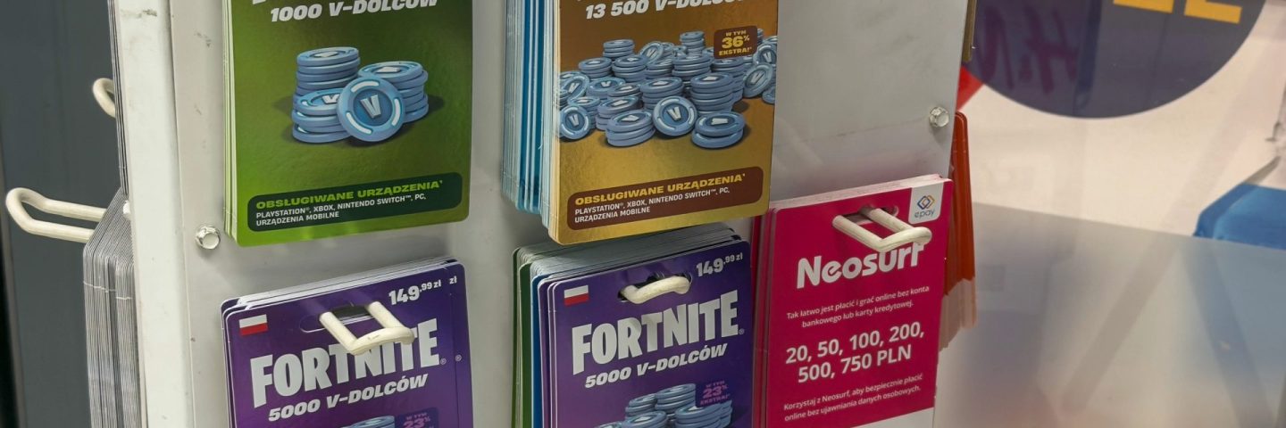 Poznan, Poland - November 22, 2025: Physical Fortnite V-DOLCOW digital currency cards and Neosurf prepaid payment vouchers for various online transactions