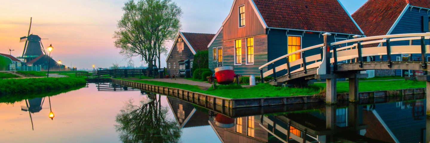 Old wooden Dutch farm Zaanse Schans Netherlands, historical wooden windmills in winter Zaanse Schans Holland during sunset.