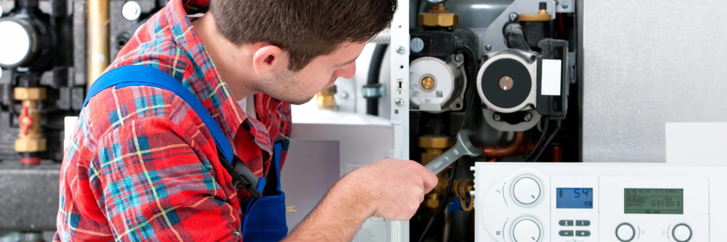 Technician servicing heating boiler