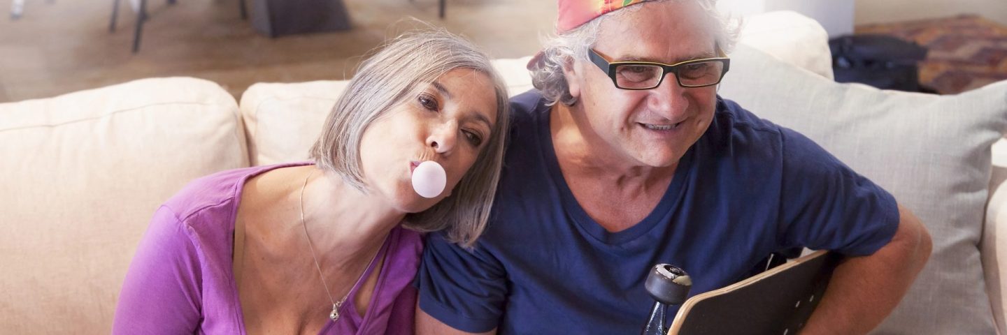 elderly couple playing at being young at home