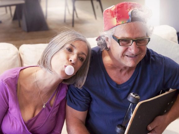 elderly couple playing at being young at home