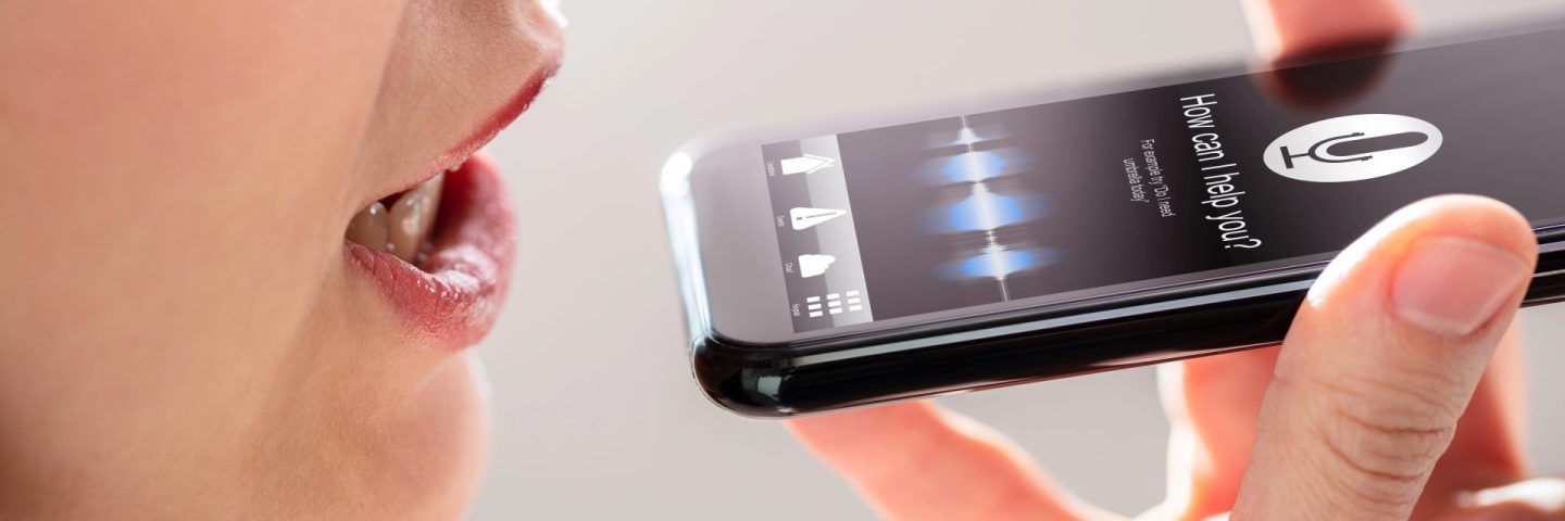 Close-up Of A Young Woman Using Voice Recognition Function On Mobile Phone