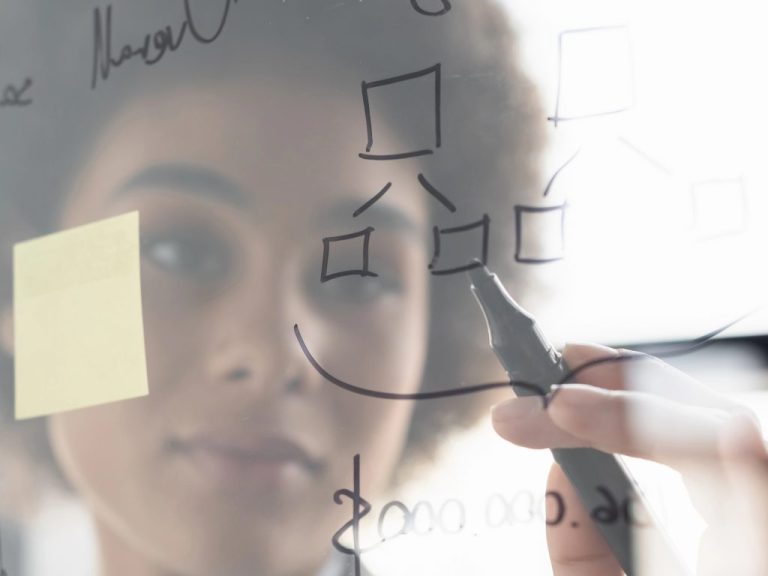 Blurred african american businesswoman writing on glass board