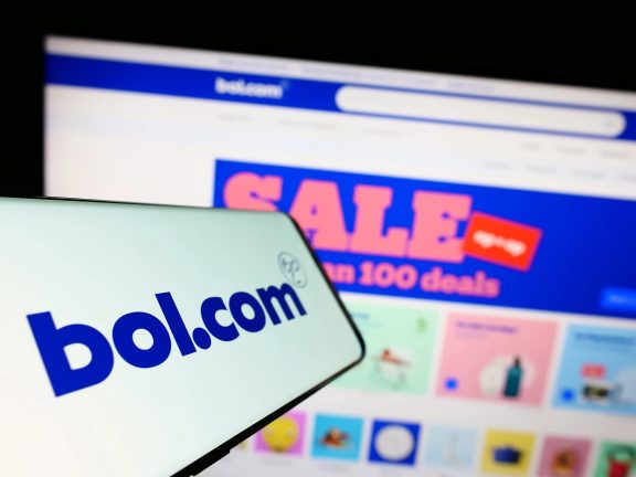 Stuttgart, Germany - 07-11-2023: Cellphone with logo of Dutch e-commerce company bol.com B.V. on screen in front of business website. Focus on center-left of phone display.