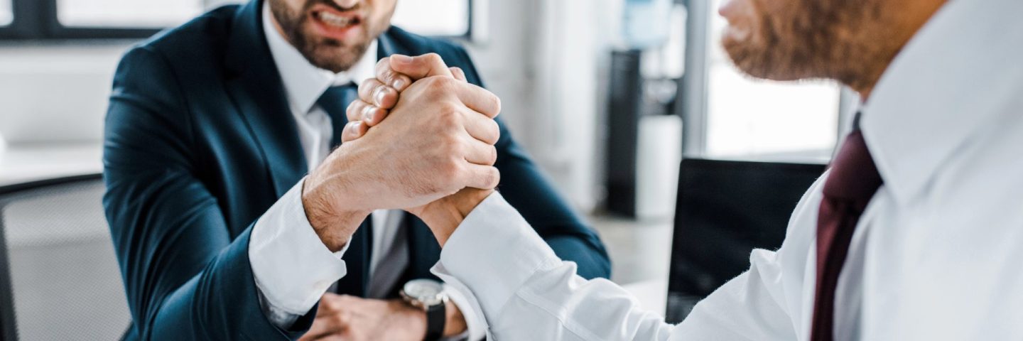 selective focus of businessmen competing arm wrestling in modern office