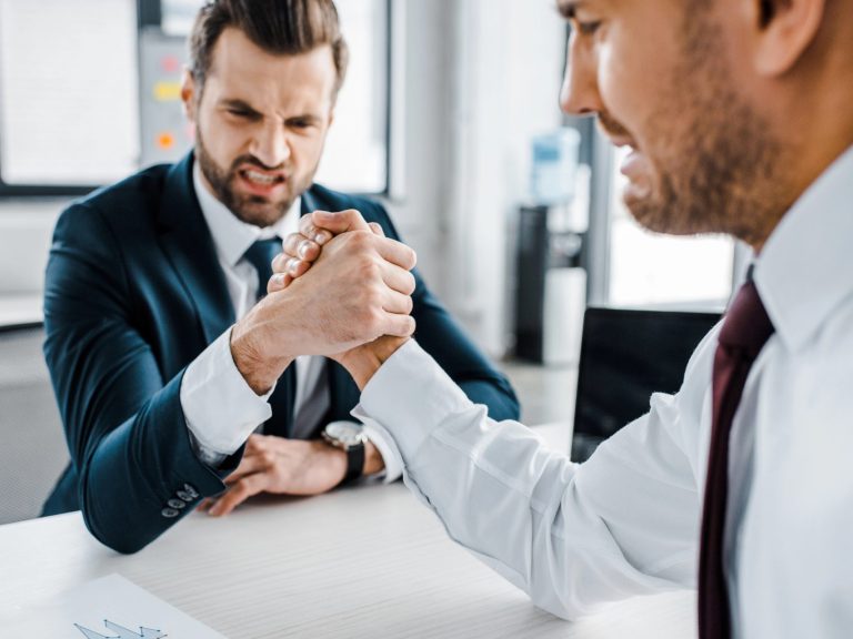 selective focus of businessmen competing arm wrestling in modern office