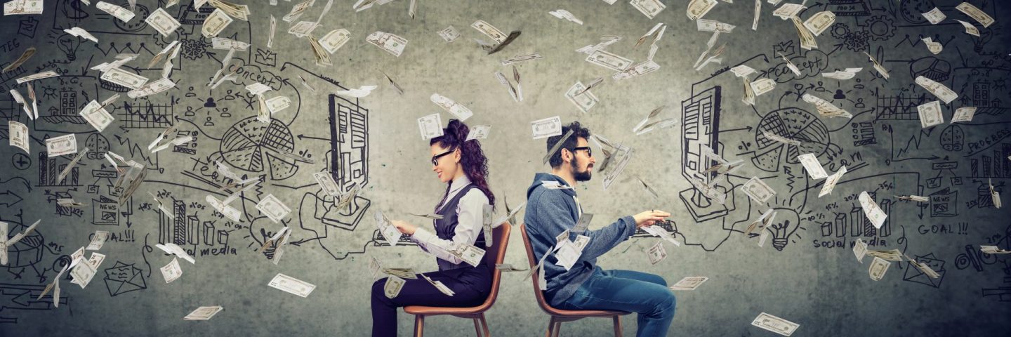 Businessman and businesswoman working on computer developing successful business strategy under money rain