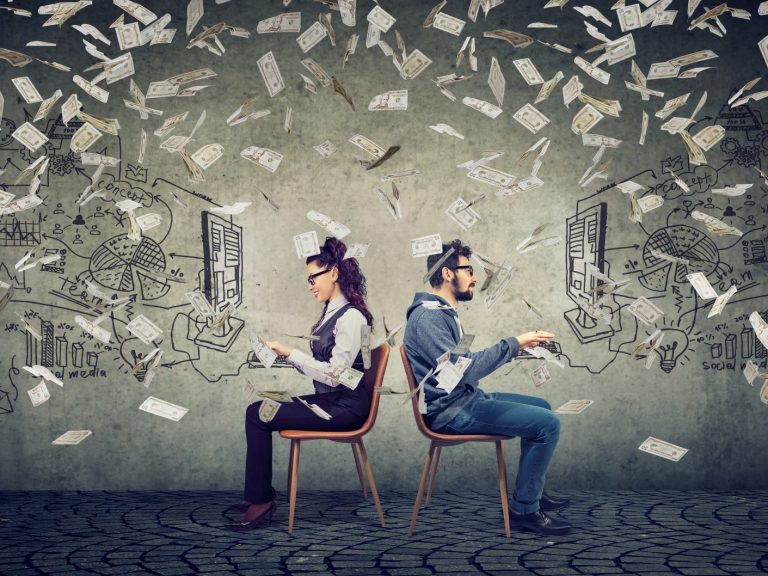 Businessman and businesswoman working on computer developing successful business strategy under money rain